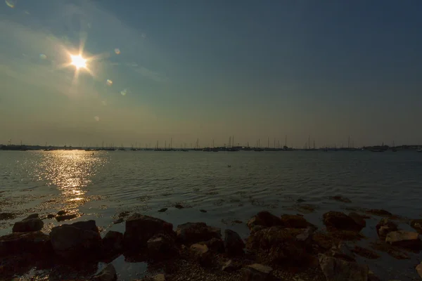 Solnedgång på en stenig strand. — Stockfoto