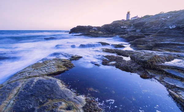 Solnedgång på en stenig strand. — Stockfoto