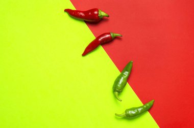 Kırmızı yeşil arka planda sıcak kırmızı ve yeşil kırmızı kırmızı biberler düz manzarada yatıyordu. Yemek için baharat, yemek için baharat, acı biber, yemek. Yaratıcı düzen, kırmızı biber deseni.