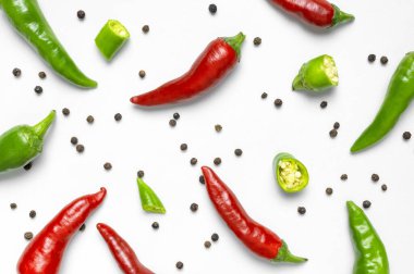 Kırmızı ve yeşil taze kırmızı biber, beyaz arka planda kuru siyah biber düz manzaralı. Yemek için baharat, yemek için baharat, acı biber, yemek. Yaratıcı düzen, kırmızı biber deseni.