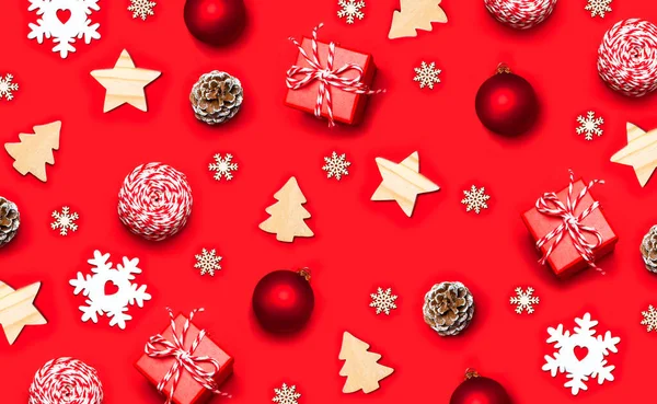 新年のクリスマスの装飾のコレクションフラットレイ ギフト 赤いクリスマスボール 松のコーン 赤い背景のトップビューの雪の結晶お祝いリボン木製のトウヒの星 デザイン パターン モックアップのレイアウト — ストック写真