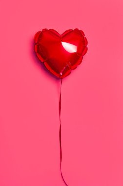 Aşk, Sevgililer Günü konsepti. Pembe zemin arkaplanda kalp şeklinde kırmızı balon düz fotokopi alanı uzanıyor. Tatil Nesnesi, Doğum günü, Düğün. Parti dekorasyonu. Gönüllü tebrik kartı.