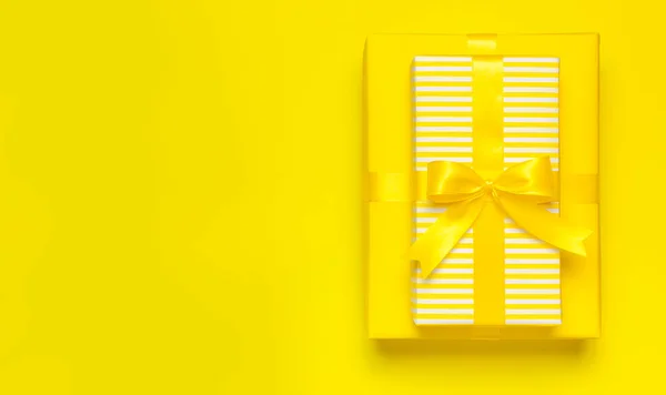 Tatil geçmişi düzdü. İki tane parlak sarı hediye paketi, kurdeleli ve sarı arka plan üst görünüm fotokopi alanı üzerinde. Doğum günü hediyesi, 8 Mart, Anneler Günü, Sevgililer Günü. Tebrikler. — Stok fotoğraf