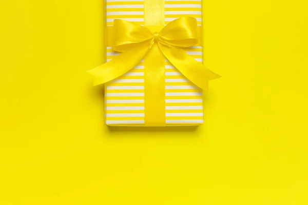 Tatil geçmişi düzdü. Parlak sarı hediye paketi, kurdeleli ve sarı arka plan üst görünüm fotokopi alanı üzerinde. Doğum günü hediyesi, 8 Mart, Anneler Günü, Sevgililer Günü. Tebrikler. — Stok fotoğraf