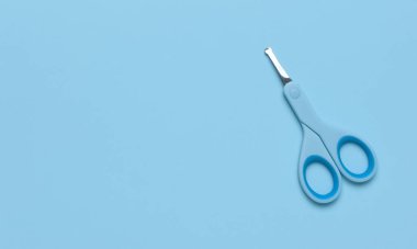 Mavi arka planda hijyen için mavi makas düz görünümde düz fotokopi alanı. Metal ve plastik bebek tırnak makası. Manikür makası. Bebek bakımı konsepti. Oğlan için makyaj malzemesi