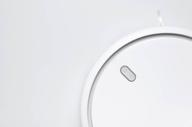 Gri arka planda modern robot elektrikli süpürge yatıyordu. Yeni teknolojiler, hızlı ev temizliği, otomatik robot asistanı. Rahatlamak için boş zaman. Gelecek teknolojisi, temizlik için akıllı aygıt..