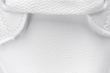 Beyaz kadın deri spor ayakkabıları, yakın çekim, makro fotoğraf. Şık gençlik ayakkabıları, spor ayakkabıları, hakiki deri ayakkabılar. Minimalist ayakkabı mağazası reklamı, moda, tarz. Ayakkabı arkaplanı.