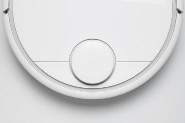 Gri arka planda modern robot elektrikli süpürge yatıyordu. Yeni teknolojiler, hızlı ev temizliği, otomatik robot asistanı. Rahatlamak için boş zaman. Gelecek teknolojisi, temizlik için akıllı aygıt..