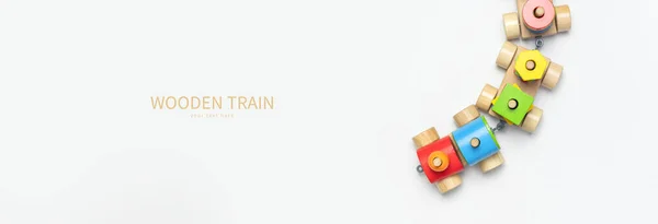 Wooden train with colored blocks on white background. Kids toys made of natural wood in rainbow colors. Eco friendly toy, game, plastic free. Toy for babies and toddlers. Flat lay.