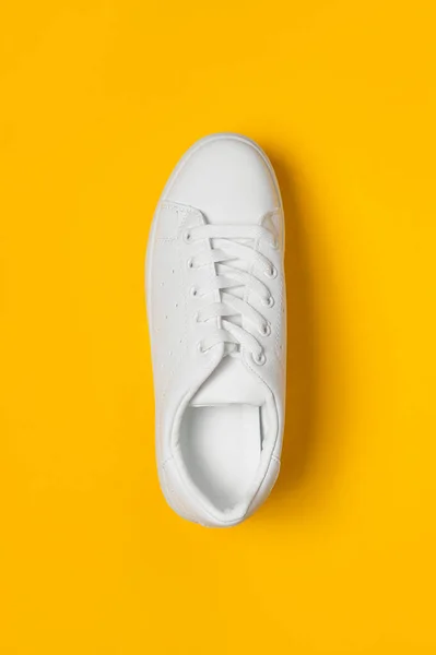 Sarı Arka Planda Beyaz Kadın Deri Spor Ayakkabıları Düz Yerde — Stok fotoğraf
