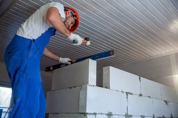 Mason alinhando bloco de concreto autoclavado aerado da parede da casa construída — Fotografia de Stock