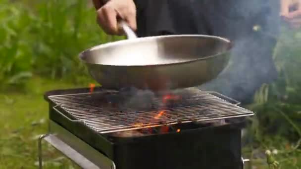 园中的庄稼人在火盆上加热油锅 — 图库视频影像