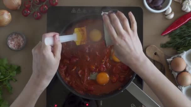 Gotować dodawanie jaj do sosu pomidorowego w patelni — Wideo stockowe