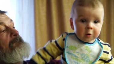 görüntüleri dedesi torununu kollarında tutar.