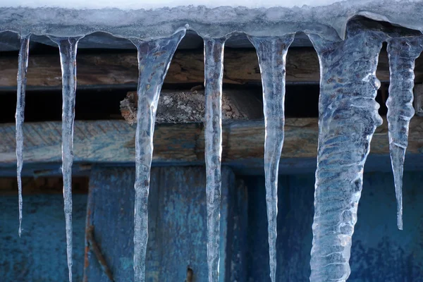 Muitos icicles pendurados no telhado de madeira — Fotografia de Stock