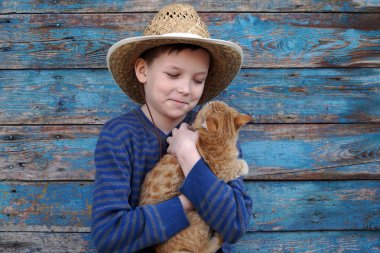 kumral bir kedi ile oynarken çocuk