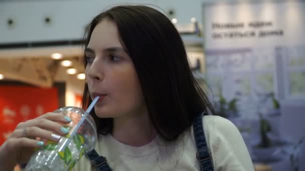 Młoda piękna dziewczyna jest picie mojito na food court — Wideo stockowe