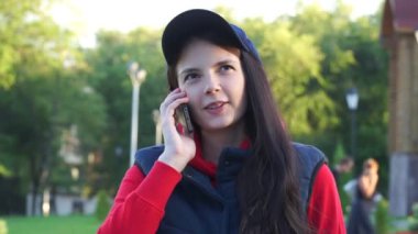 bir kap içinde genç kız parkta ve telefonda konuşurken içeri girer