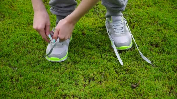 Girl stopped running to tie the laces on running shoes. fitness girl training outdoors — Stock Video
