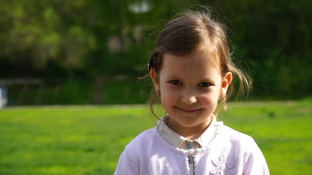Кадри на відкритому повітрі маленька дівчинка дивиться на камеру . — стокове відео