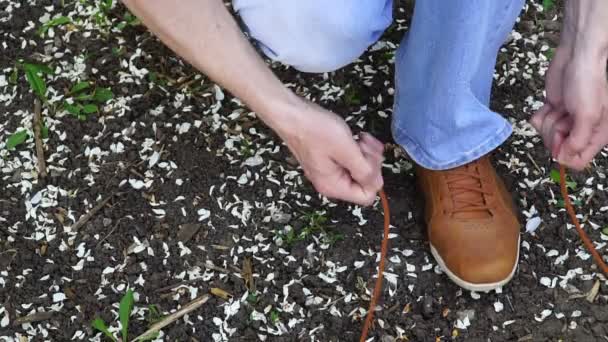 Hombres comete un paseo al aire libre y se detiene para atar sus cordones en zapatillas de deporte . — Vídeos de Stock