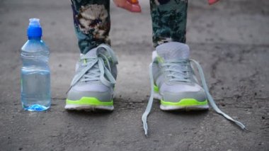 kız koşu ayakkabıları üzerinde dantel bağlamaya çalışan durdu. Fitness kız eğitim açık havada.