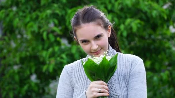 Metraje mujer está oliendo los tulipanes en el jardín — Vídeo de stock