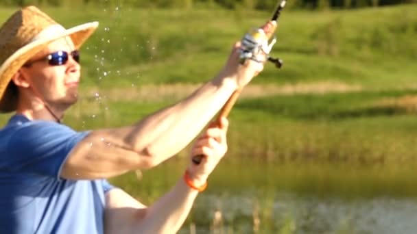 Запись рыбак ловит хищных рыб с прядением на озере . — стоковое видео