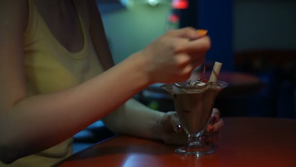 Filmagem mulher sentada em um café e comer sorvete — Vídeo de Stock