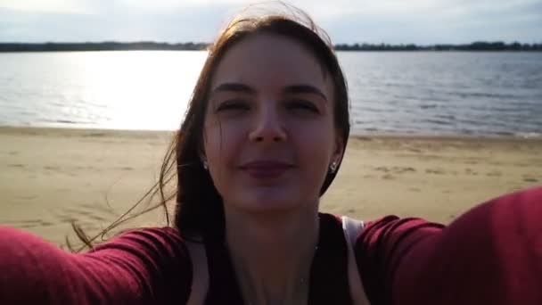川の背景にスマート フォンで selfie を行う映像若い女性 — ストック動画