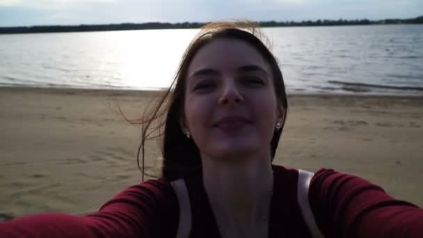 Запись молодая женщина делает селфи на вашем смартфоне на фоне реки — стоковое видео