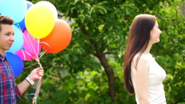 Запись молодой человек держит воздушные шары и дает им молодую девушку — стоковое видео
