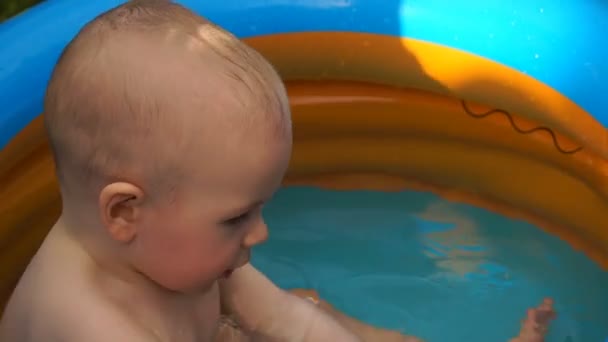 Footage infant boy swimming in pool and play with fish toy. — Stock Video