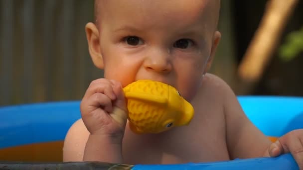 Filmación niño nadando en la piscina y jugar con el juguete de pescado . — Vídeos de Stock