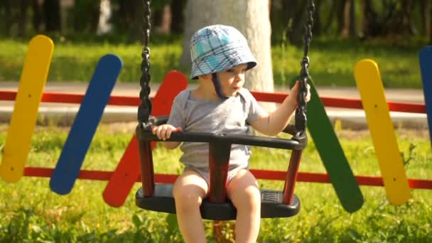 Filmación niño balanceándose en un columpio en el parque . — Vídeo de stock