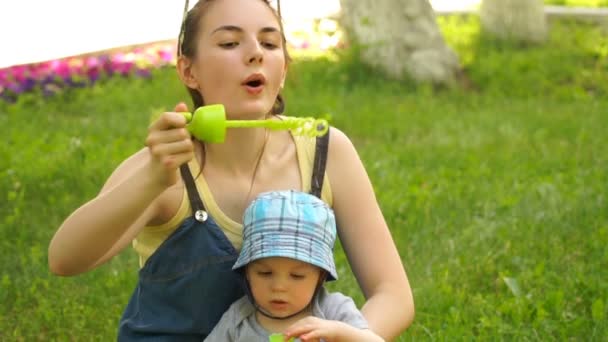 Μήκος σε πόδηα γυναίκα με γιο φυσώντας φυσαλίδες στην φύση — Αρχείο Βίντεο