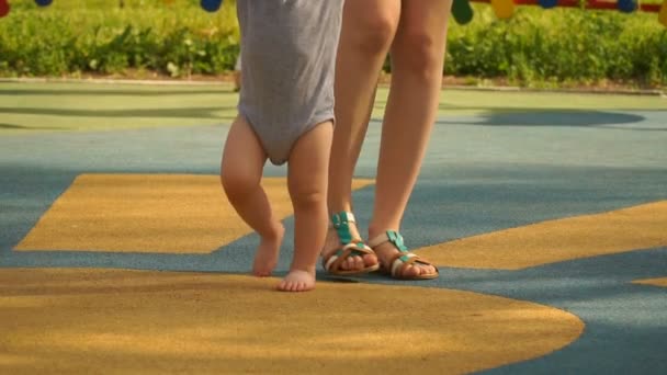 Filmación joven madre aprender su hijo a caminar . — Vídeos de Stock