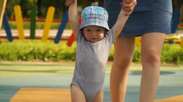 Filmagem jovem mãe aprender seu filho a andar . — Vídeo de Stock