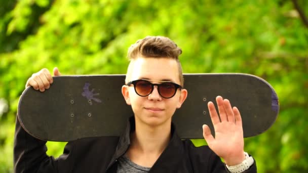 Záběry teenager skateboardista drží brusle a při pohledu na fotoaparát. 4k — Stock video