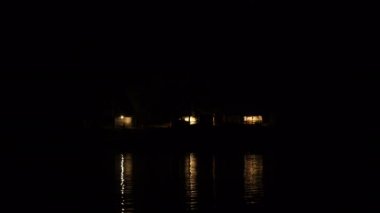 Görüntüleri bir kamp dağlarda, ışıklar gelen ışık su yansıtıyordu. 4k