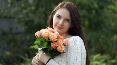 bir buket gül açık havada tutan kadın