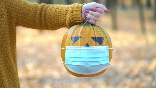 Mujer sosteniendo calabaza jack-o-lantern en el parque de otoño — Vídeos de Stock