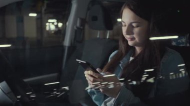 Kadın otoparktaki arabada otururken telefonuna başvurmuş.