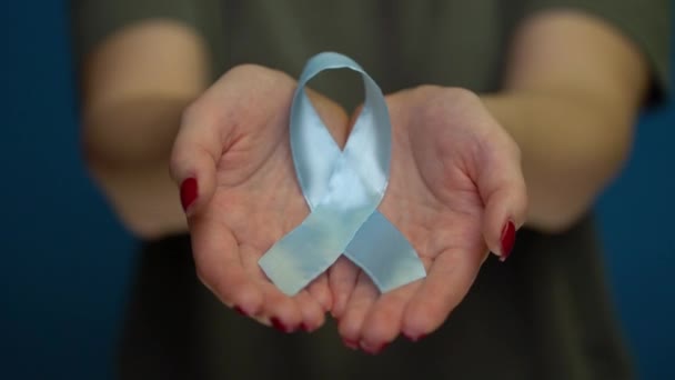 World diabetes day. Blue ribbon symbolic isolated with hand support. — Stock Video