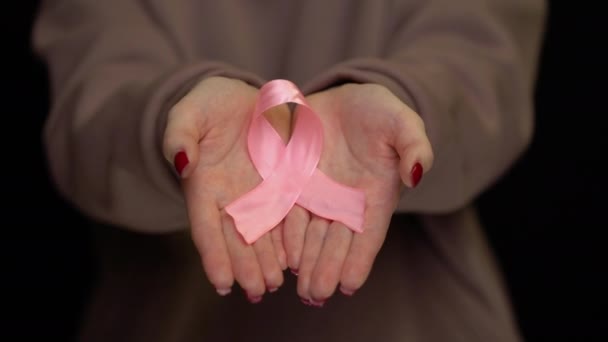 Hands holding breast cancer ribbon — Stock Video