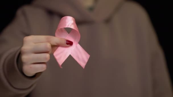 Hands holding breast cancer ribbon — Stock Video