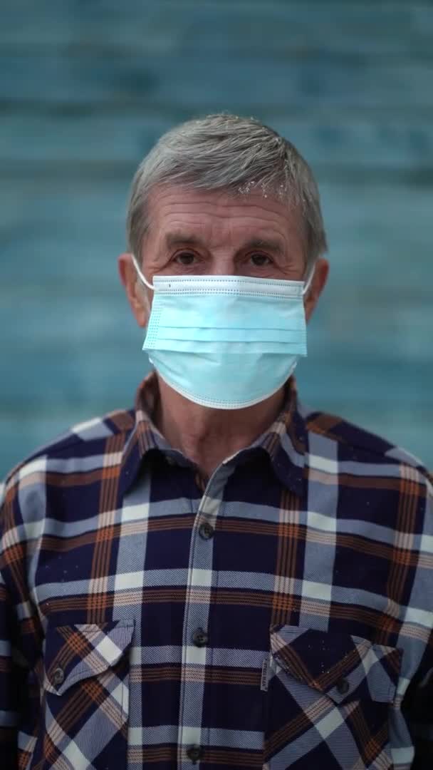 En gammal man använder ansiktsmask för att skydda mot virus mot den andra vågen karantänvirus COVID-19 pandemi. — Stockvideo