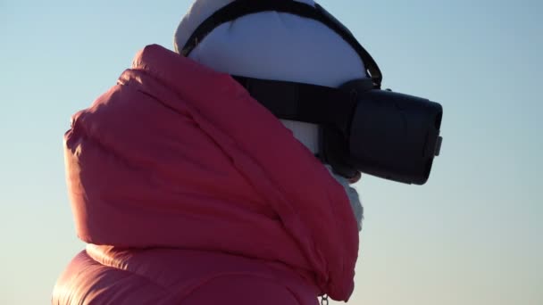 Chica mira en las gafas de realidad virtual al aire libre en invierno. — Vídeo de stock