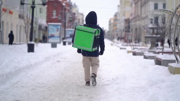 Courier levert voedsel met rugzak in de winter — Stockvideo