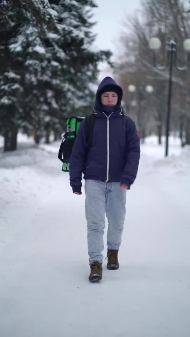 Kurier liefert im Winter Lebensmittel mit Rucksack aus — Stockvideo